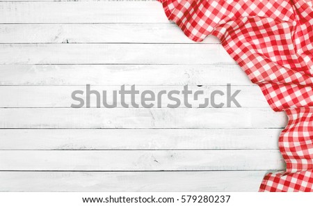 White old vintage wooden table with a red checkered tablecloth. 