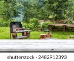 White old vintage wooden top table with blurred green nature backyard and grill bbq for party