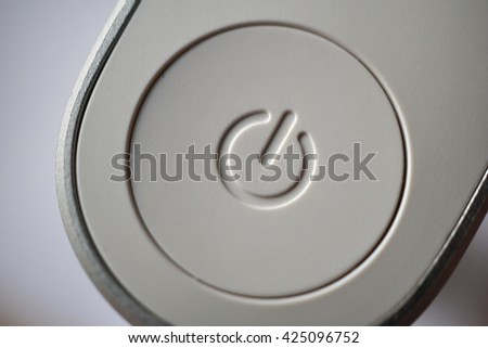 White ON and OFF circle button used to turn on and turn off the electric equipment in the modern design made of silver aluminum and white plastic 