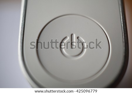 White ON and OFF circle button used to turn on and turn off the electric equipment in the modern design made of silver aluminum and white plastic 