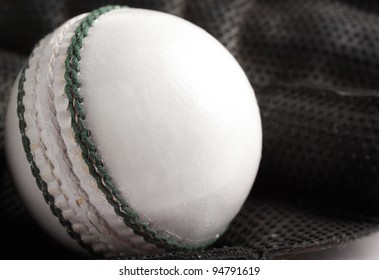 A White One Day Or Twenty-20 Match Cricket Ball In A Wicket Keeping Glove.