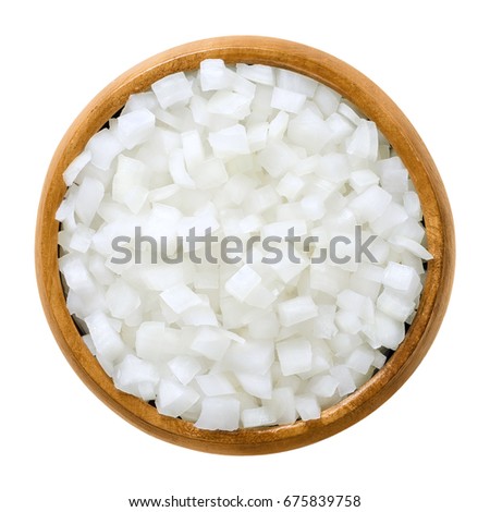 White onion cubes in wooden bowl. Chopped fresh, raw Allium cepa, also bulb or common onion. Vegetable, ingredient and staple food. Isolated macro food photo close up from above on white background.