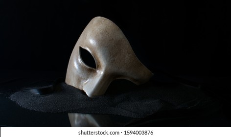 white opera mask with sand and cloth