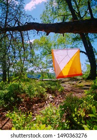 White Orange Flag Marks Checking Point For Orienteering Run Hangs On Tree In Difficult Forest And Rocky Terrain In Sandstone Rocky Park. 