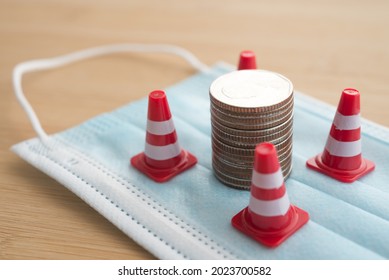 White Orange Under Construction Cone Around Stacked Coins On Mask. World Economy Crisis Due To COVID-19, Fix Repair Or Reset Investment Plan, Money Saving Management. Business And Financial Concept.