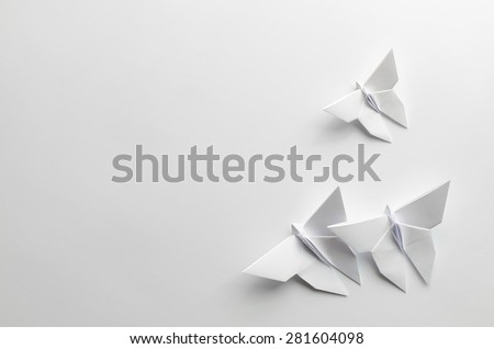 White origami butterflies on white background