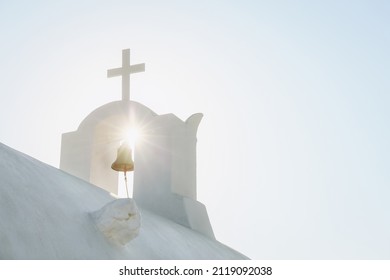 White Orthodox Church belfry with cross and bell in sunshine on sky background. Santorini island, Greece - Shutterstock ID 2119092038