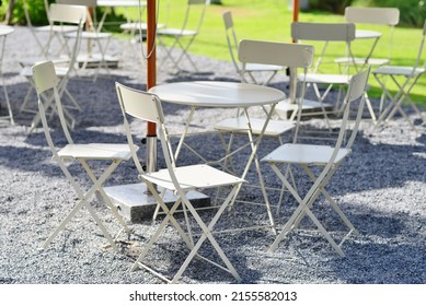 Weiße Außenstühle wurden mit einem Tisch aufgestellt.