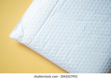 White Padded Envelope With Bubble Wrap On Yellow Background, Top View