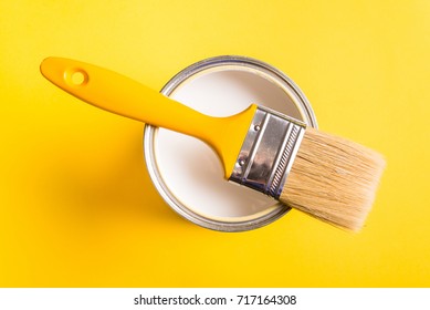 White Paint Can With Brush Top View On Yellow Background.