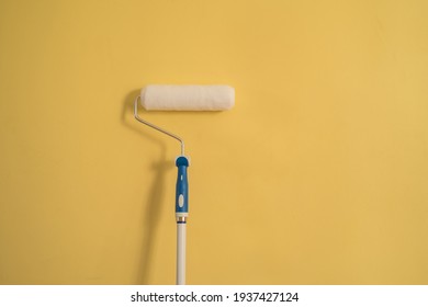 White Paint Roller On A Yellow Wall