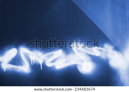 White paint sprayed on a blue metal background