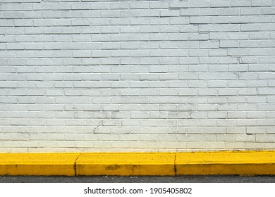 White Painted Brick Wall With Yellow Sidewalk