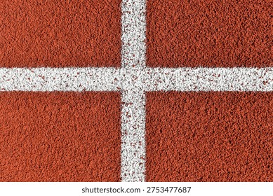 White painted cross intersection lines on red running track texture