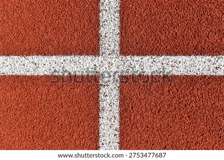 White painted cross intersection lines on red running track texture