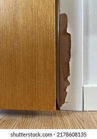 White Painted Door Frame With Paint Peeling Off To Reveal Wooden Door Frame With Wooden Door And Wooden Floor