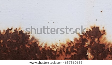white painted metal wall with rusty spot