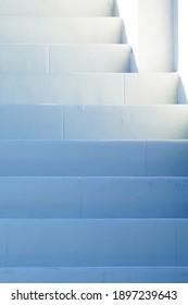 White painted stairs shaded in the blue afternoon light outside in the fresh air, getting lighter towards the top