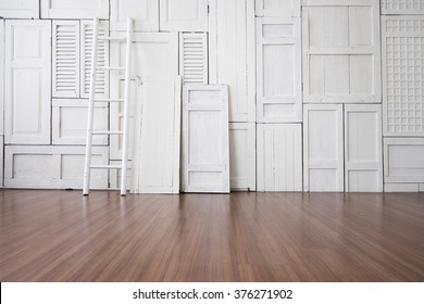 White painted window hinge on wall with white ladder on wooden floor  - Powered by Shutterstock