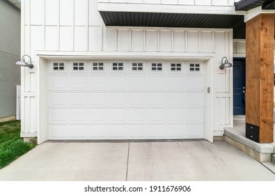 White Panelled Wooden Door Of The Attached Garage Of Home With Small Glass Panes