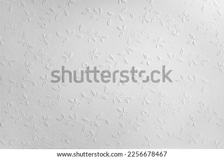 white paper background with embossed flowers, copy space, textured floral pattern