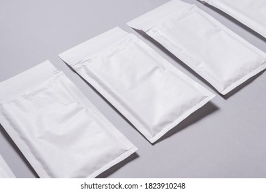 Lot of white paper bubble envelopes on grey background, textured