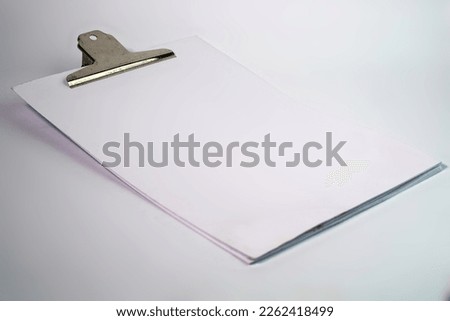white paper clipped with silver metal paperclip diagonal position on white isolated background
