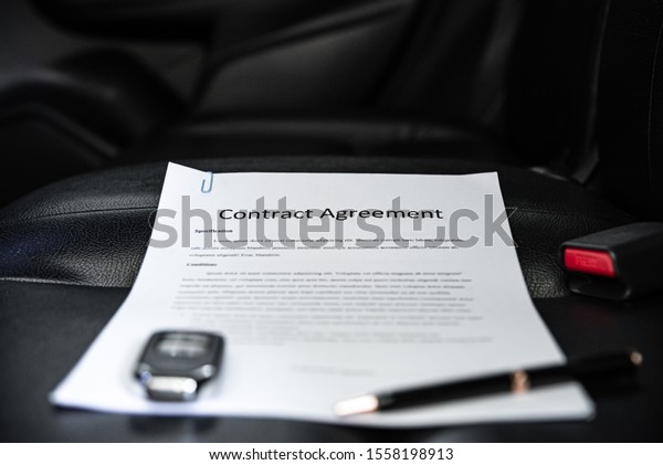 White paper contract document detail with luxury pen\
and empty space for authorized signature on sitting seat inside\
modern car