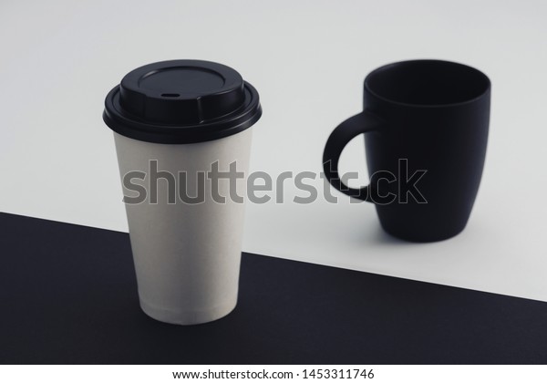 white paper cup and black coffee cup on black\
and white background