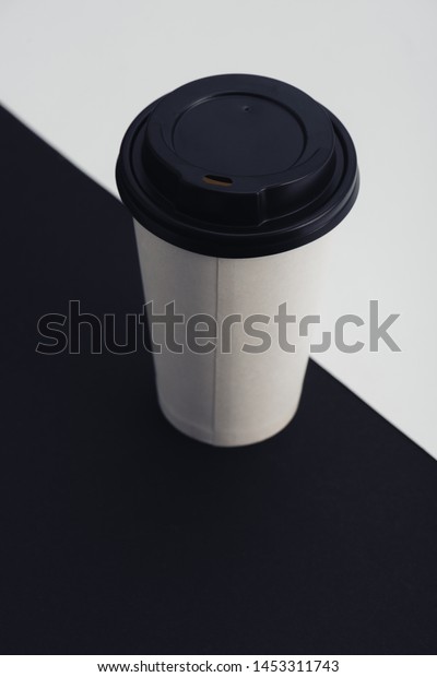 white\
paper cup on black and white divided\
background