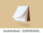 White paper desk calendar flipping page mockup isolated on brown background