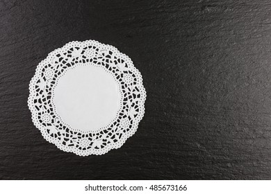 White Paper Doily On Black Slate Background