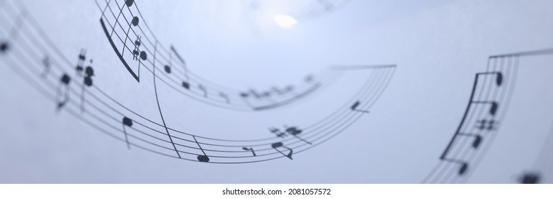 White paper with musical notes rolled up closeup background. Music writing concept