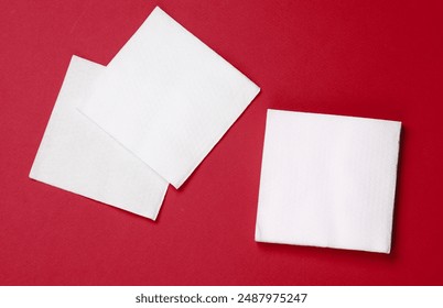 White paper napkins on a red background. Top view