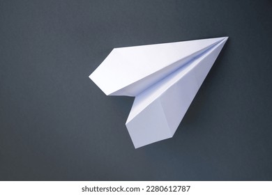White paper plane origami isolated on a blank grey background