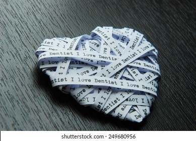 White paper ribbon in heart shape showed text 'I love dentist'