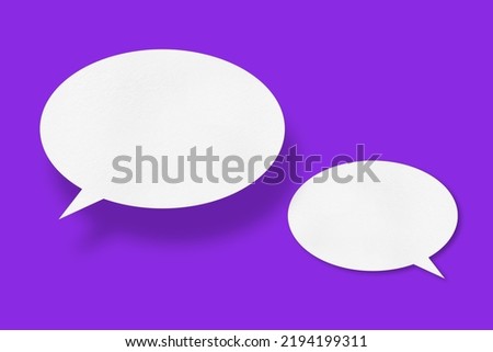 White paper in the shape of speech bubbles against a purple background. Communication bubbles.Design