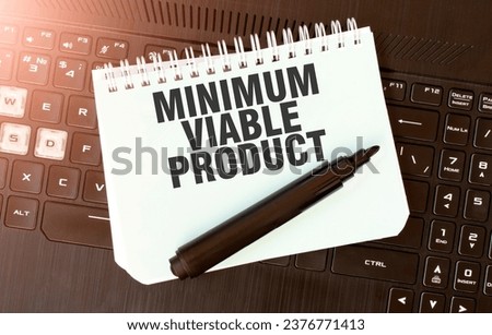 White paper sheet with text MINIMUM VIABLE PRODUCT on the black laptop