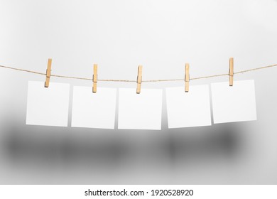 white paper sheets to dry on a rope on a white background
