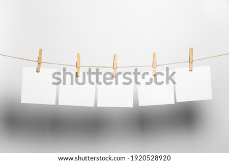 white paper sheets to dry on a rope on a white background