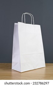 White Paper Shopping Bag On Wooden Retail Store Table.