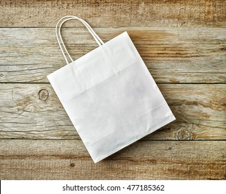 White Paper Shopping Bag On Wooden Table, Top View