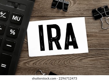 White paper with text IRA on a wooden surface with stationery
