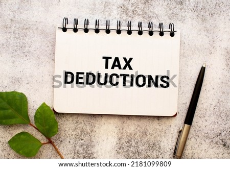 white paper with text Tax Deductions on a yellow background with stationery.