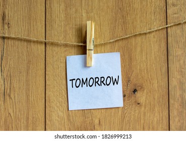 White paper with text 'tomorrow', clip on wood clothespin. Beautiful wooden background. Business concept. Copy space. - Shutterstock ID 1826999213