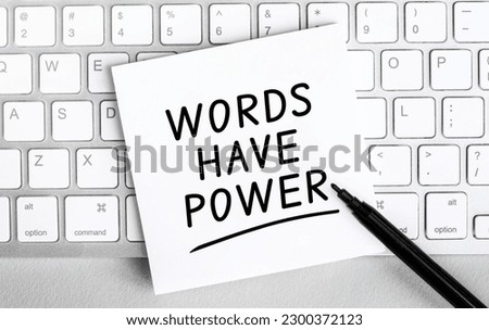 White paper with text Words have power lying on the keyboard