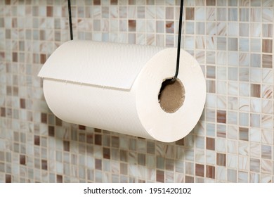 White Paper Towel Roll Hanging On A String In Kitchen