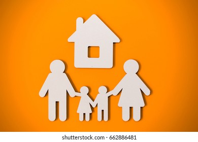 White Papercut Family Silhouette Under Home On A Orange Background - Loan Concept