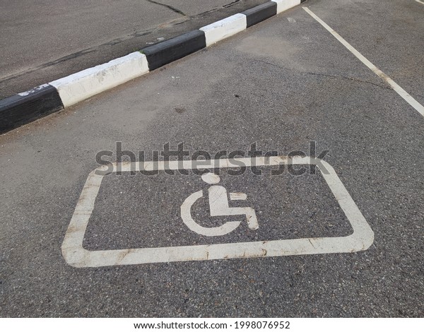 white\
parking sign for the disabled on the\
asphalt