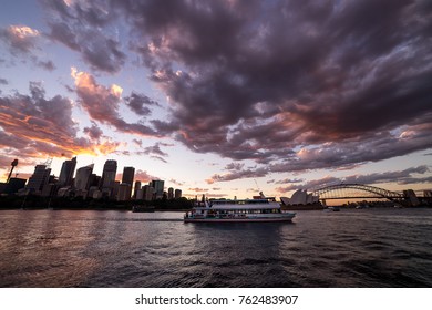 A White Party Boat Cruise On Harbour With City, Opera House And Harbour Bridge Background During Sunset Time  View From Botanic Garden Sydney, Australia 12/11/17